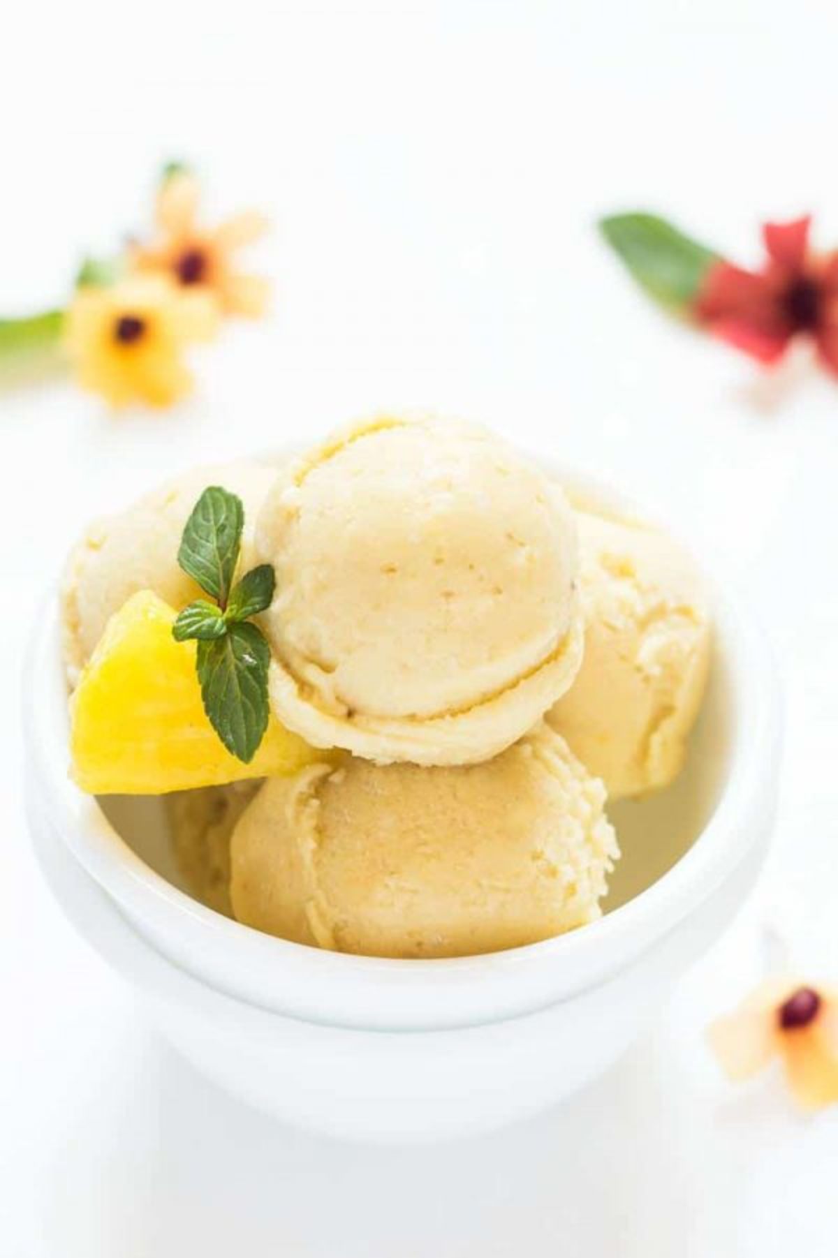 Scrumptious homemade creamy pineapple ice cream in a white bowl.