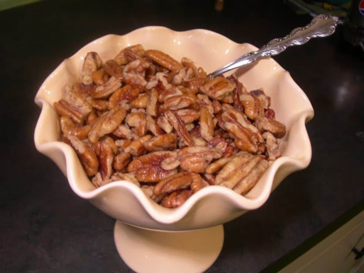 Crunchy mother's pecans in a pink bowl with a spoon.