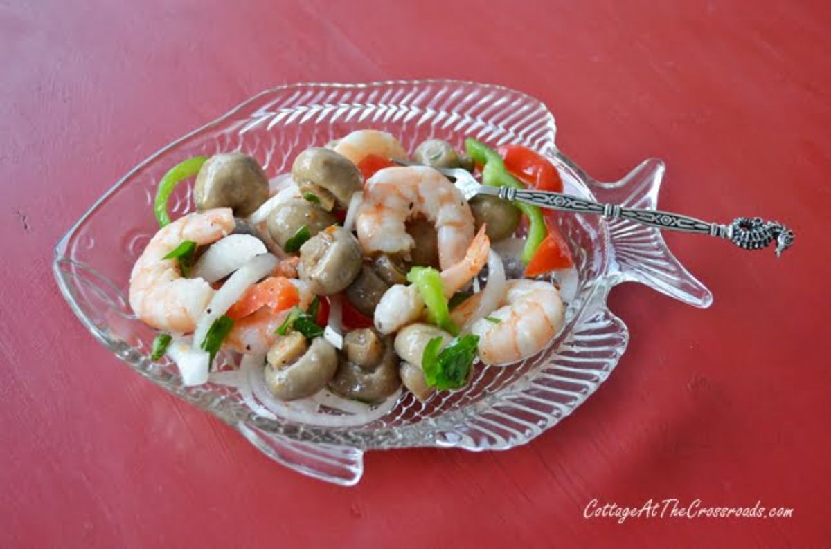 Healthy marinated shrimp and crab on a glass fish-shaped tray.