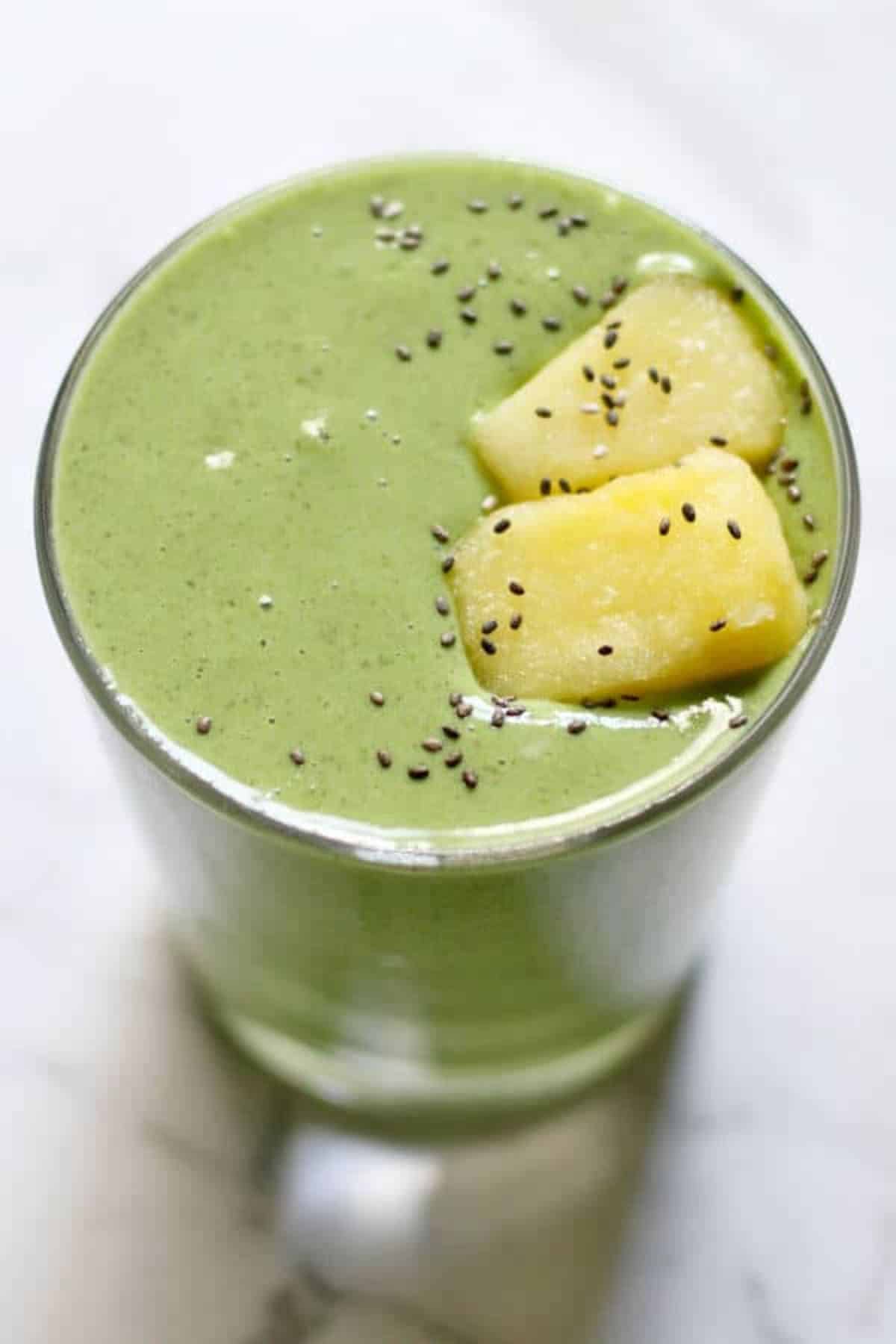 Healthy kale and pineapple smoothie in a glass cup.