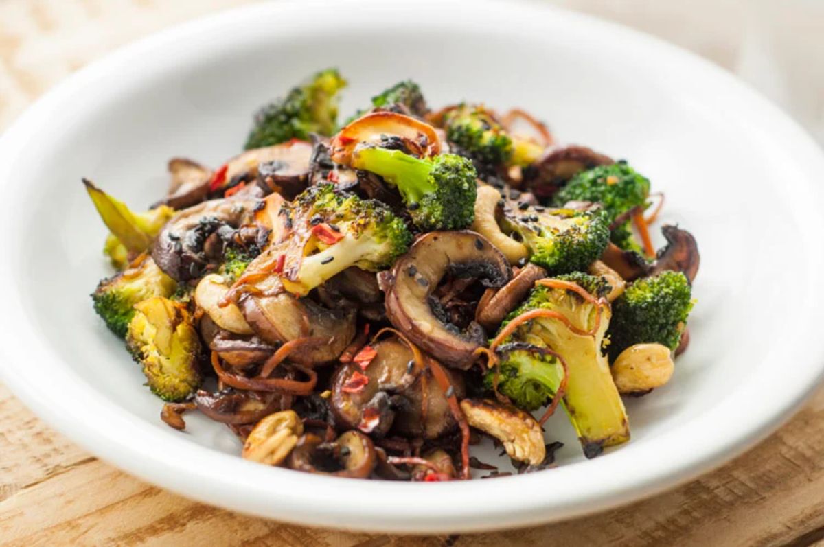 Healthy broccoli and mushroom stir-fry on a white plate.