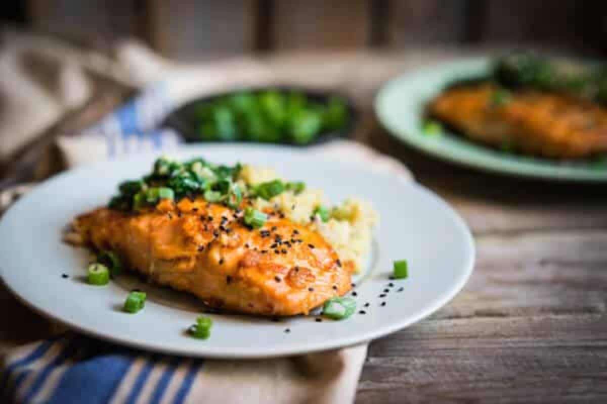Mouth-watering grilled old bay salmon on a white plate.