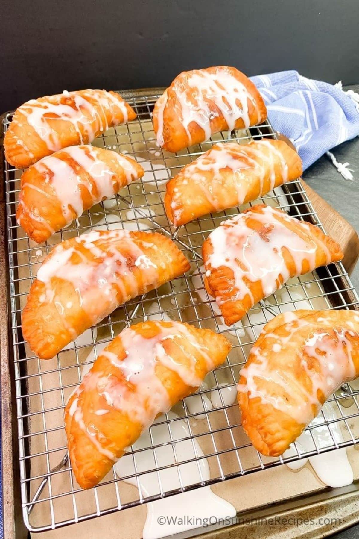 Crispy fried peach pies on a resting grid.