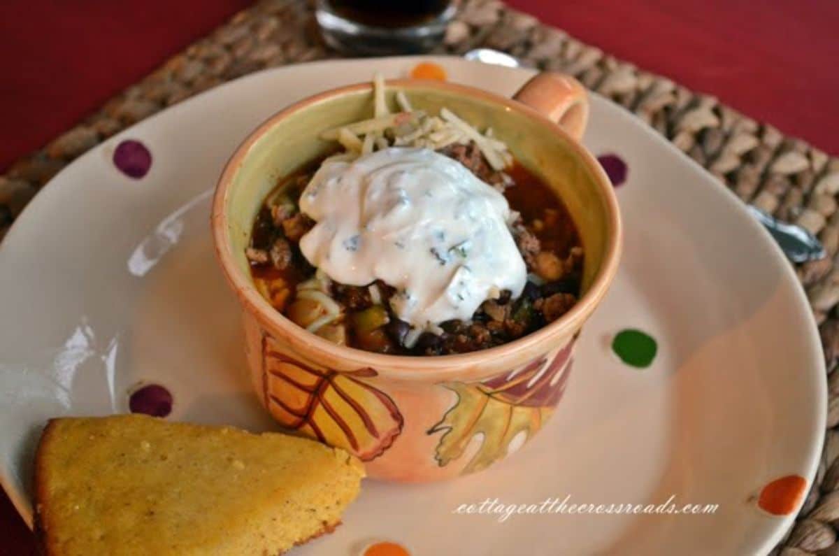 Scrumptious chili in a small pot on a plate.