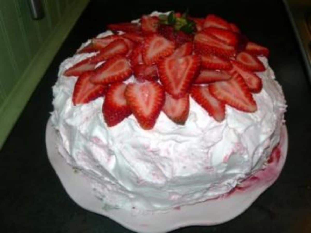 Mouth-watering strawberry cake on a cake tray.