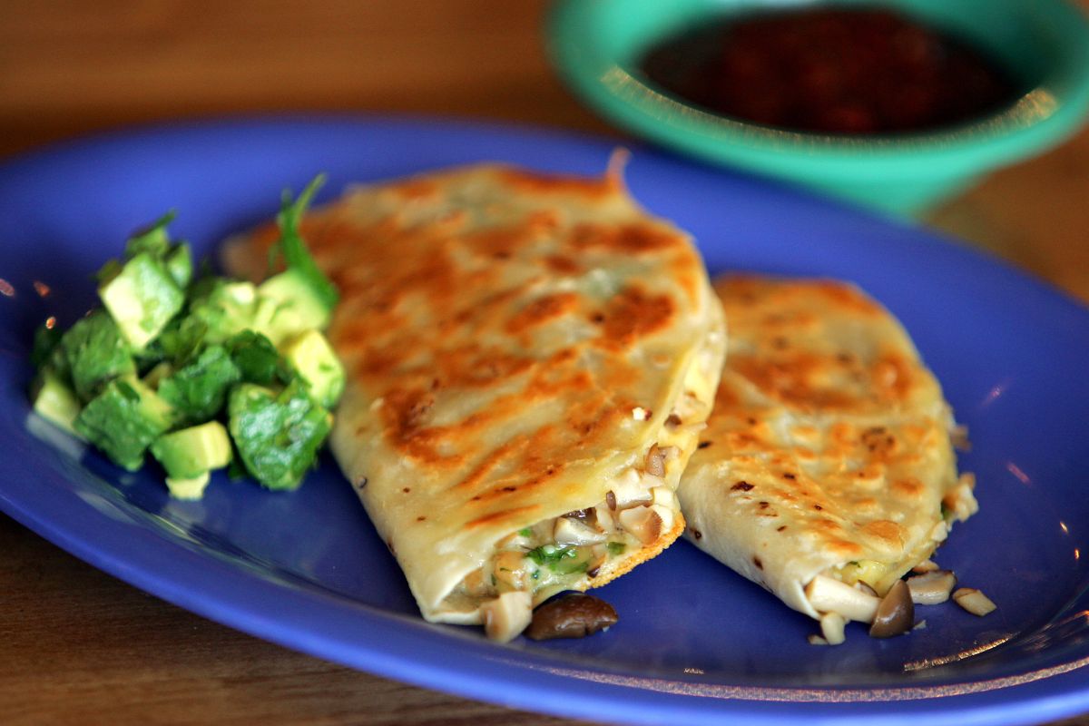 Two wild mushroom quesadillas on a blue tray.