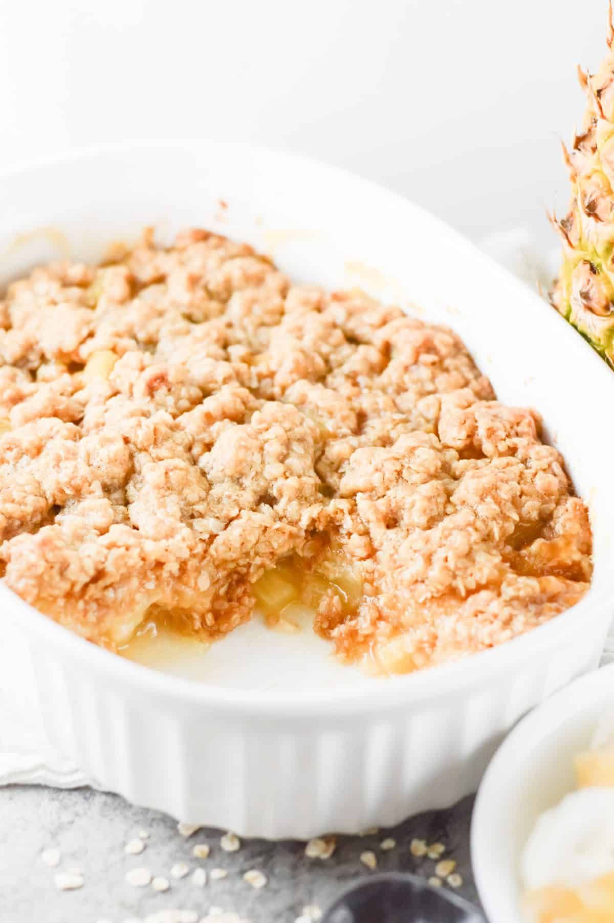 Tasty pineapple crisp in a white casserole.