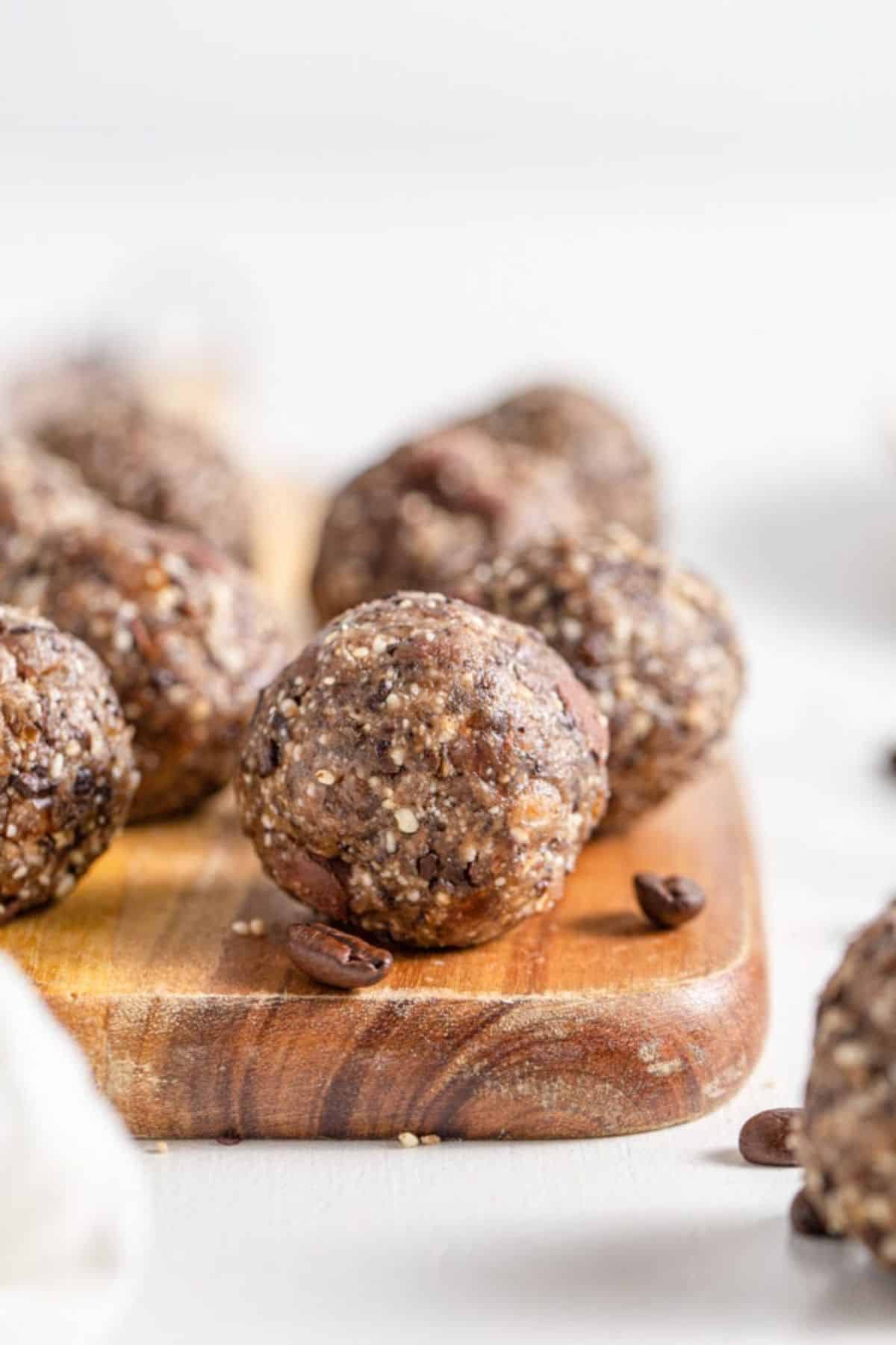 Scrumptious chocolate coffee energy bites on a wooden cutting board.