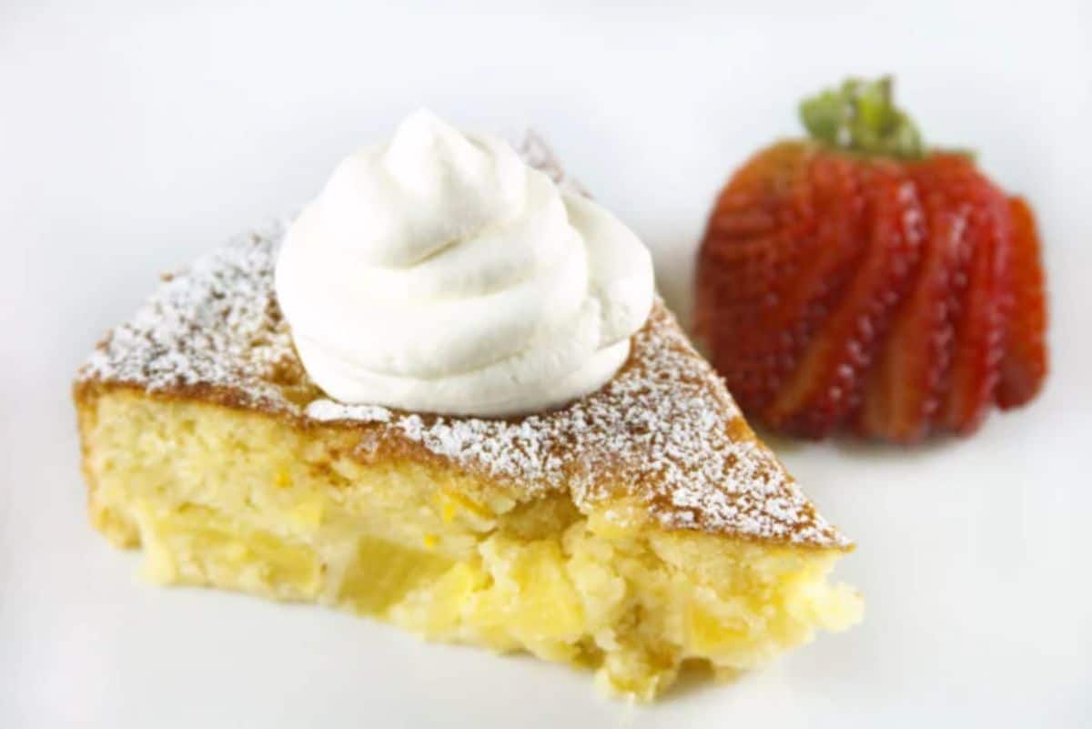 A piece of pineapple and butter cake on a white tray.