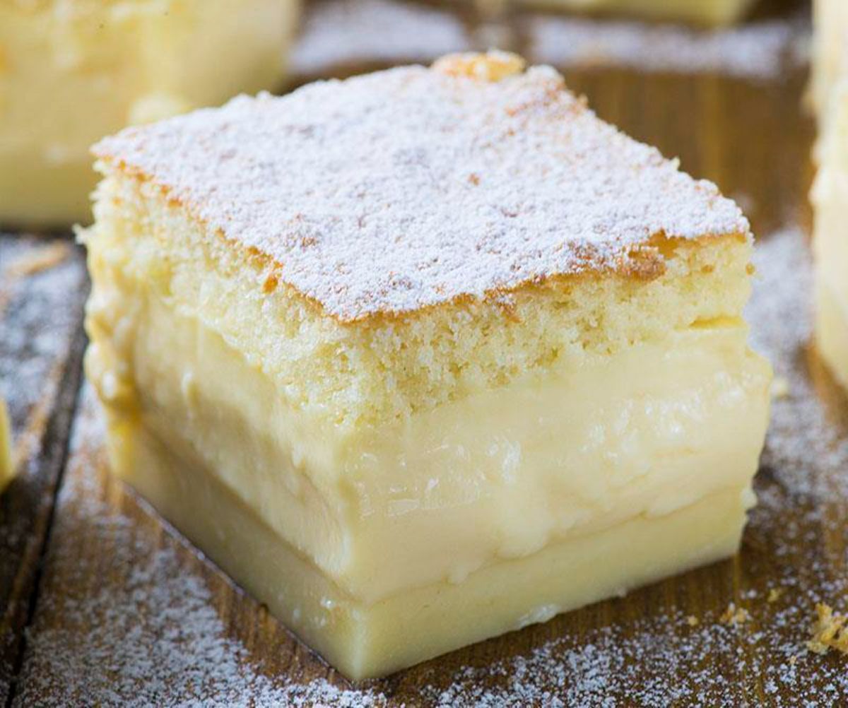 A piece of vanilla magic custard cake on a wooden table.