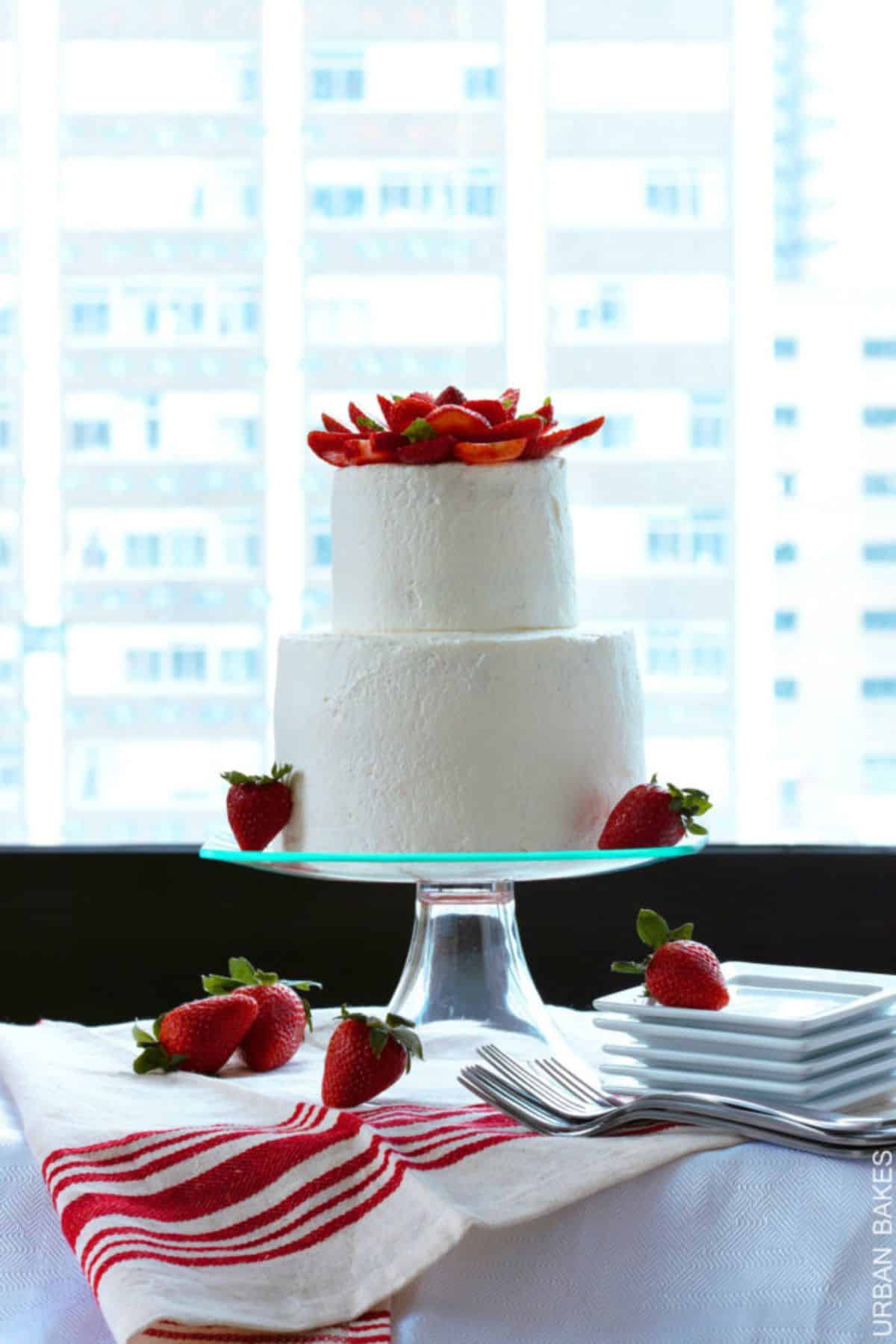 Mouth-watering strawberry urban cake on a glass cake tray.