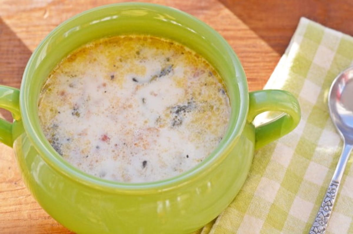 Creamy zuppa toscana soup in a green pot.