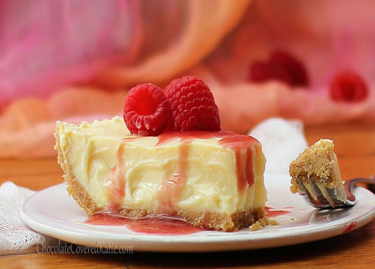 A piece of healthy high protein greek yogurt cheesecake on a white plate with a fork.