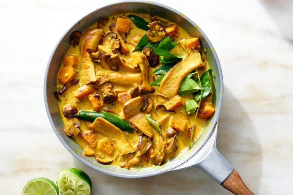 Juicy winter squash and wild mushroom curry in a skillet.