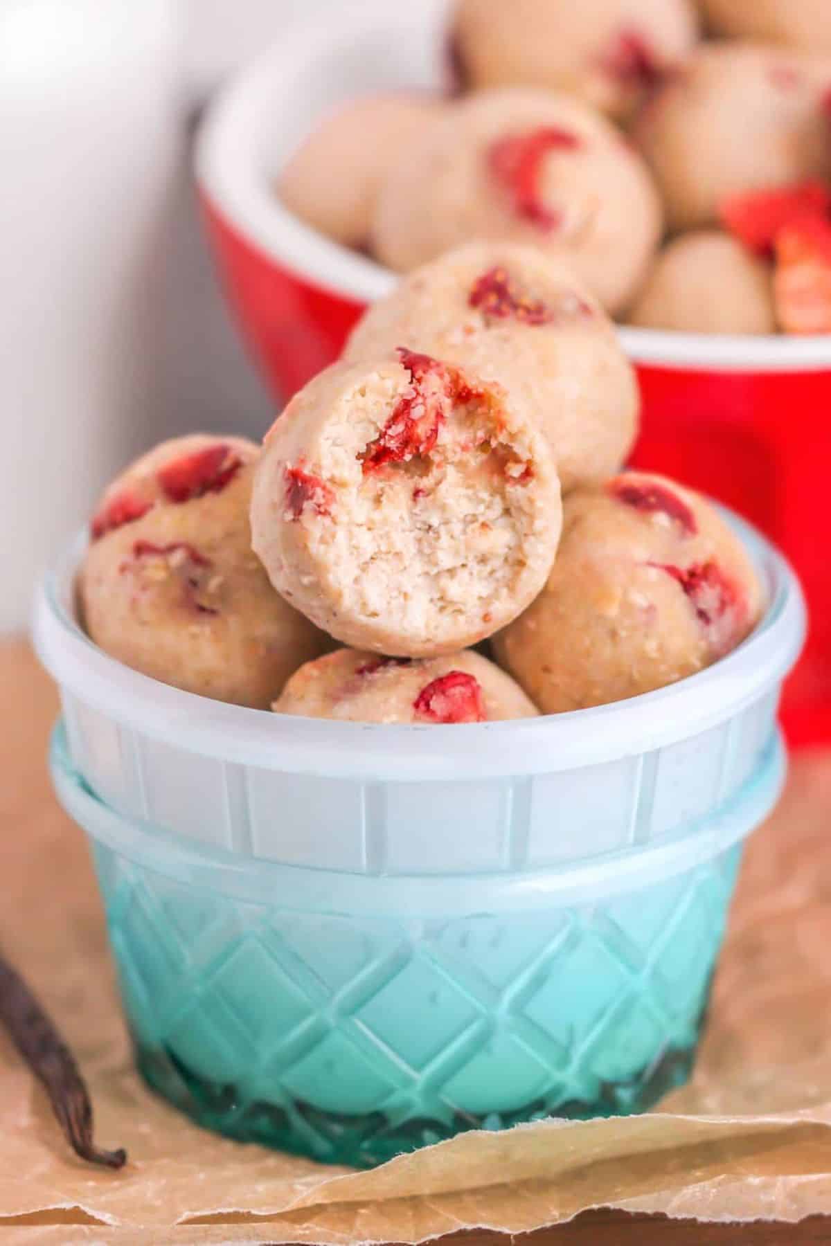 Healthy strawberry shortcake energy bites in a blue bowl.