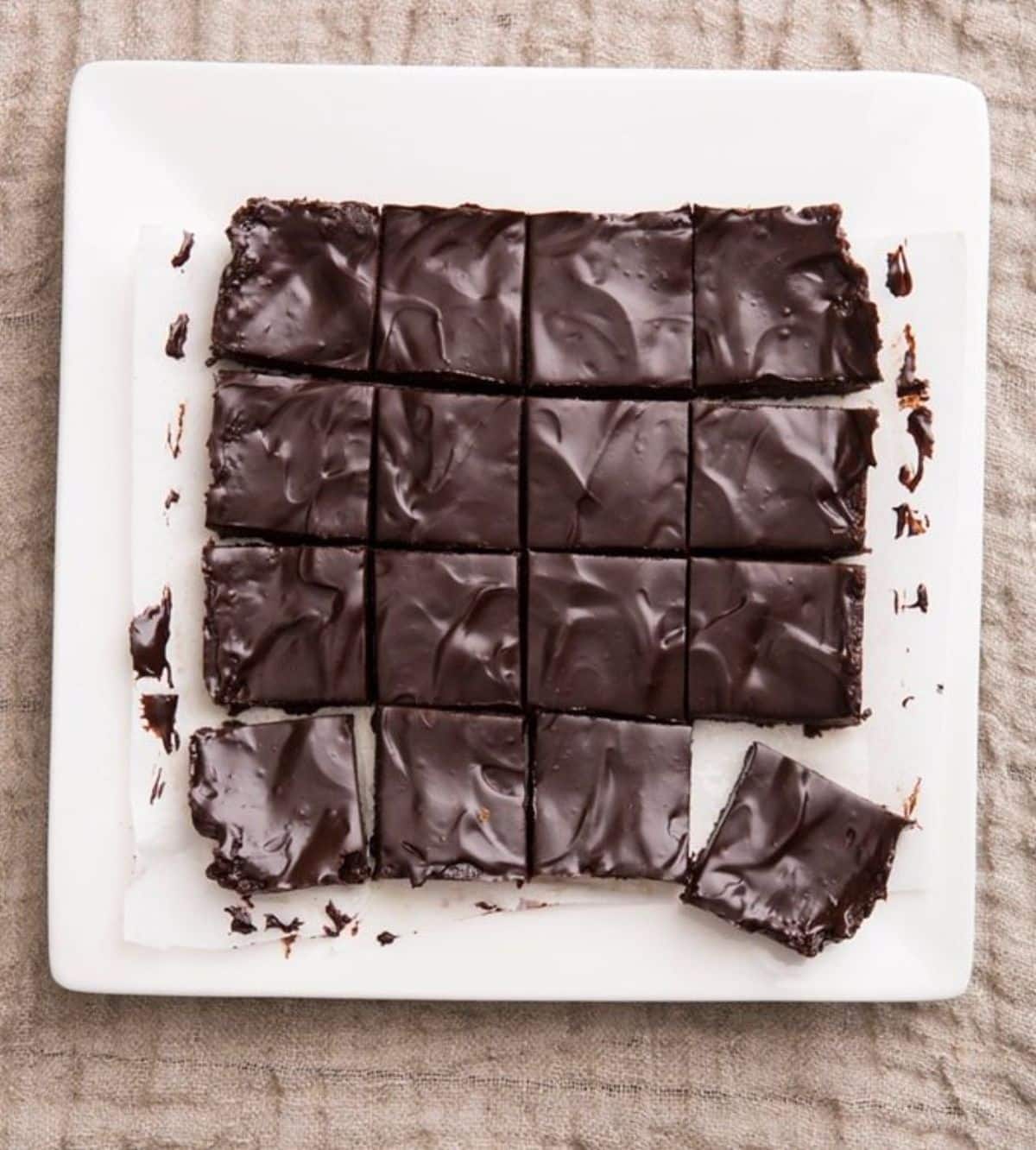 Tasty unbaked brownies on a white plate.