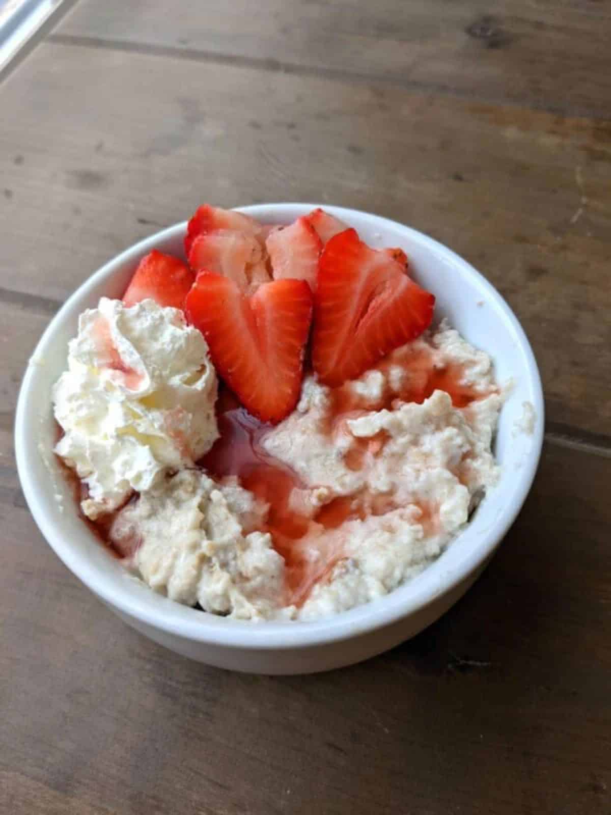 Healthy strawberries & cream egg white oatmeal in a white bowl.