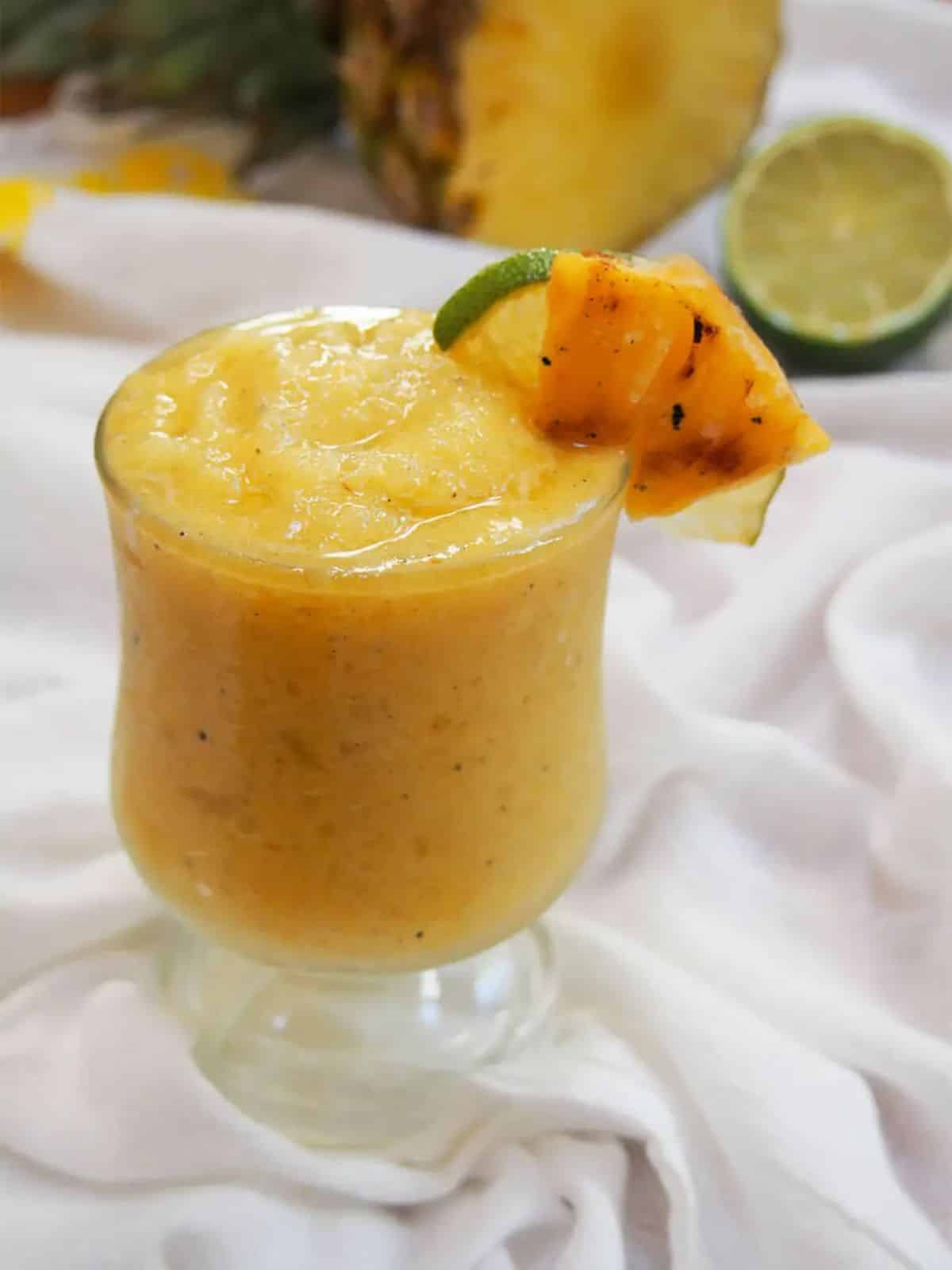 Fresh frozen alcoholic pineapple daiquiri in a tall glass.