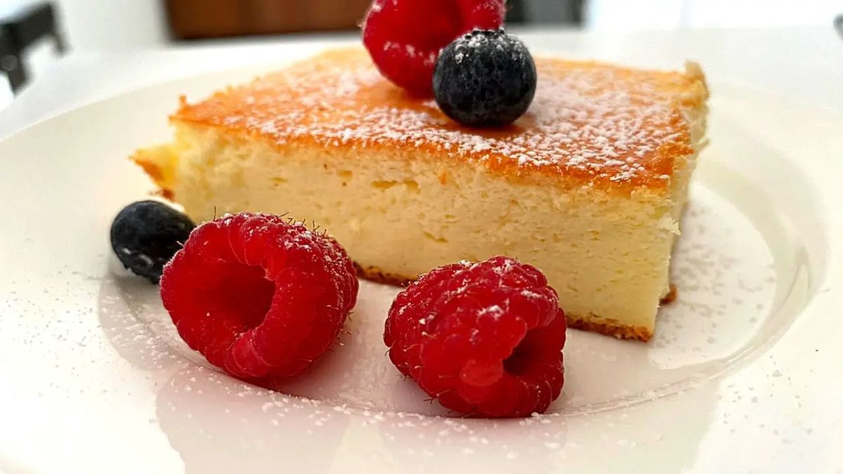 A piece of greek yogurt cake with fruits on a white plate.