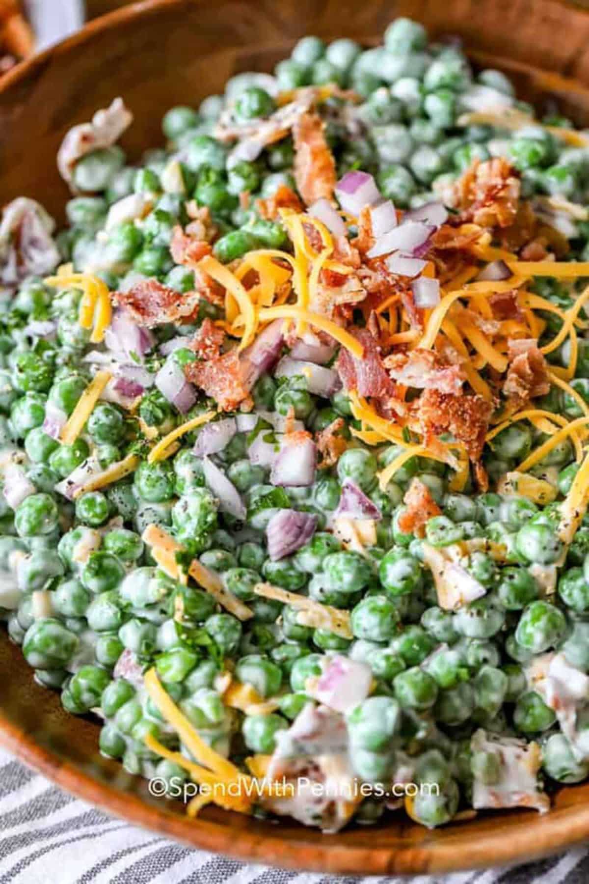 Scrumptious bacon pea salad in a wooden bowl.