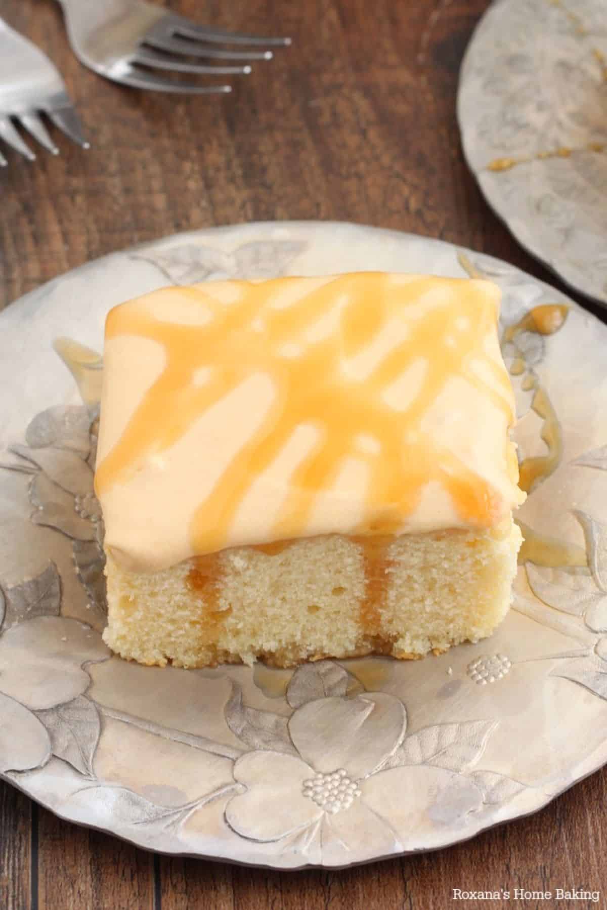 A piece of caramelized yogurt cake with caramel frosting on a plate.