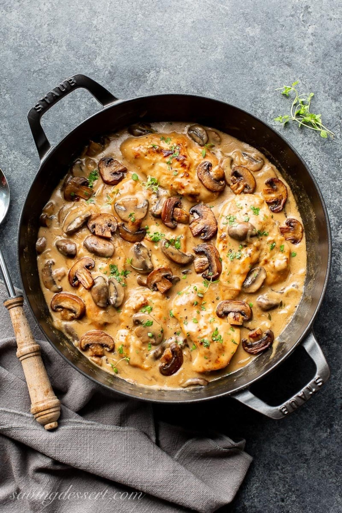 Mouth-watering chicken with mushroom wine sauce in a black skillet.