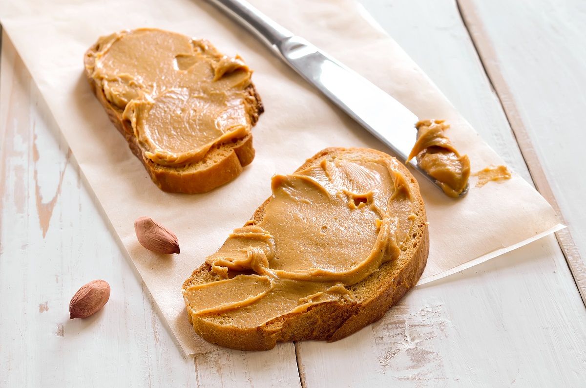 Healthy peanut butter banana sandwiches on a wooden table.