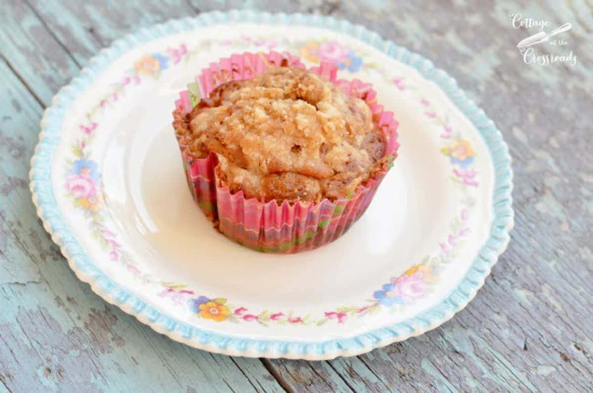 Delicious apple banana pecan muffin with streusel topping on a colorful plate.