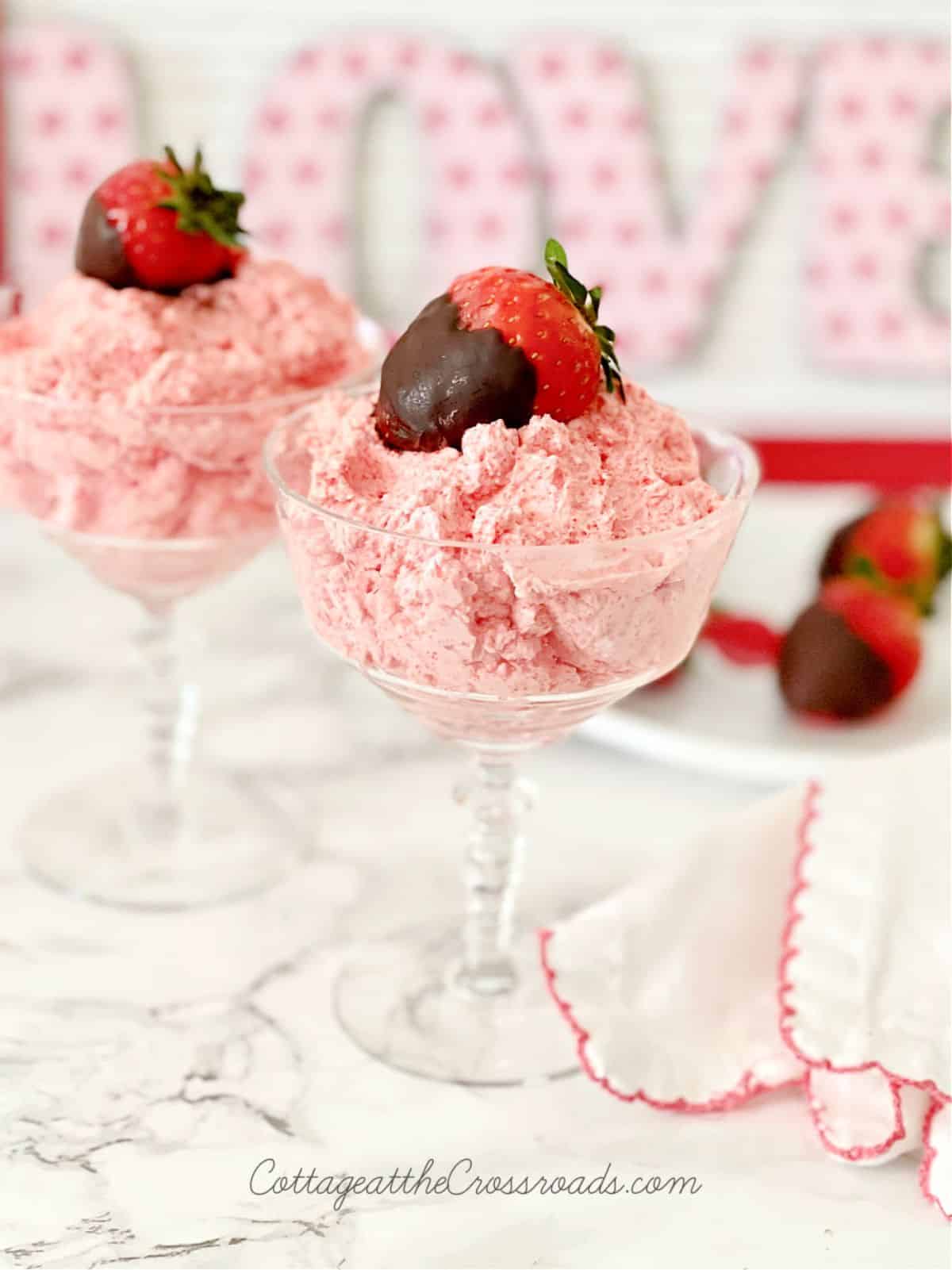 Mouth-watering strawberry fluffs in tall glasses on a table.