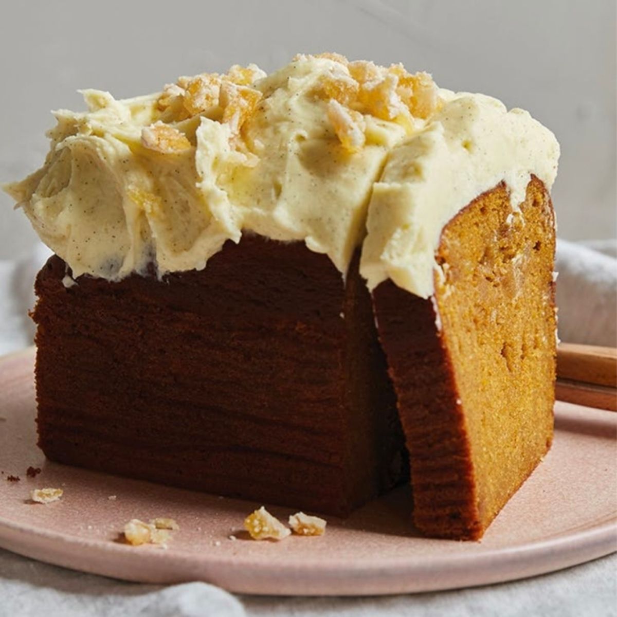 Flavorful spiced sweet potato cake with cream cheese frosting on a pink plate.