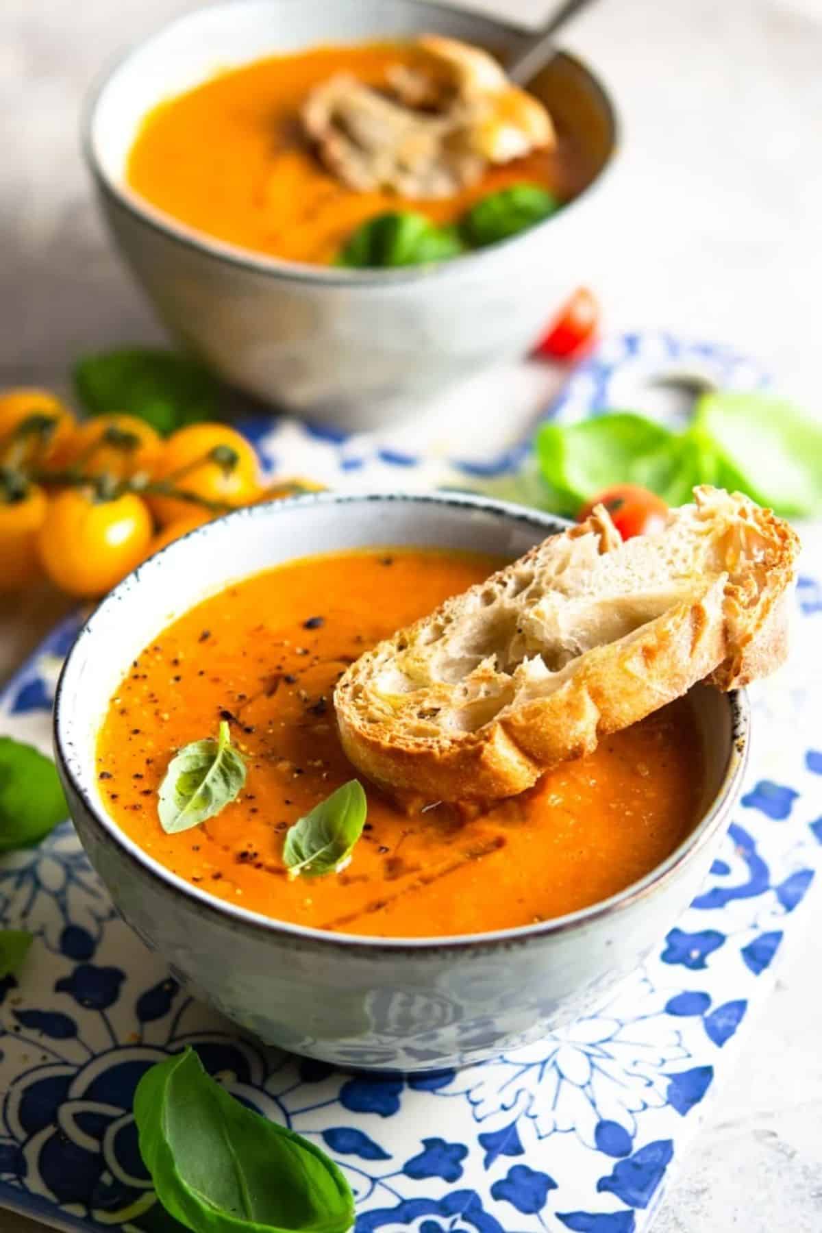 Creamy tomato soup with a piece of bread in a bowl.