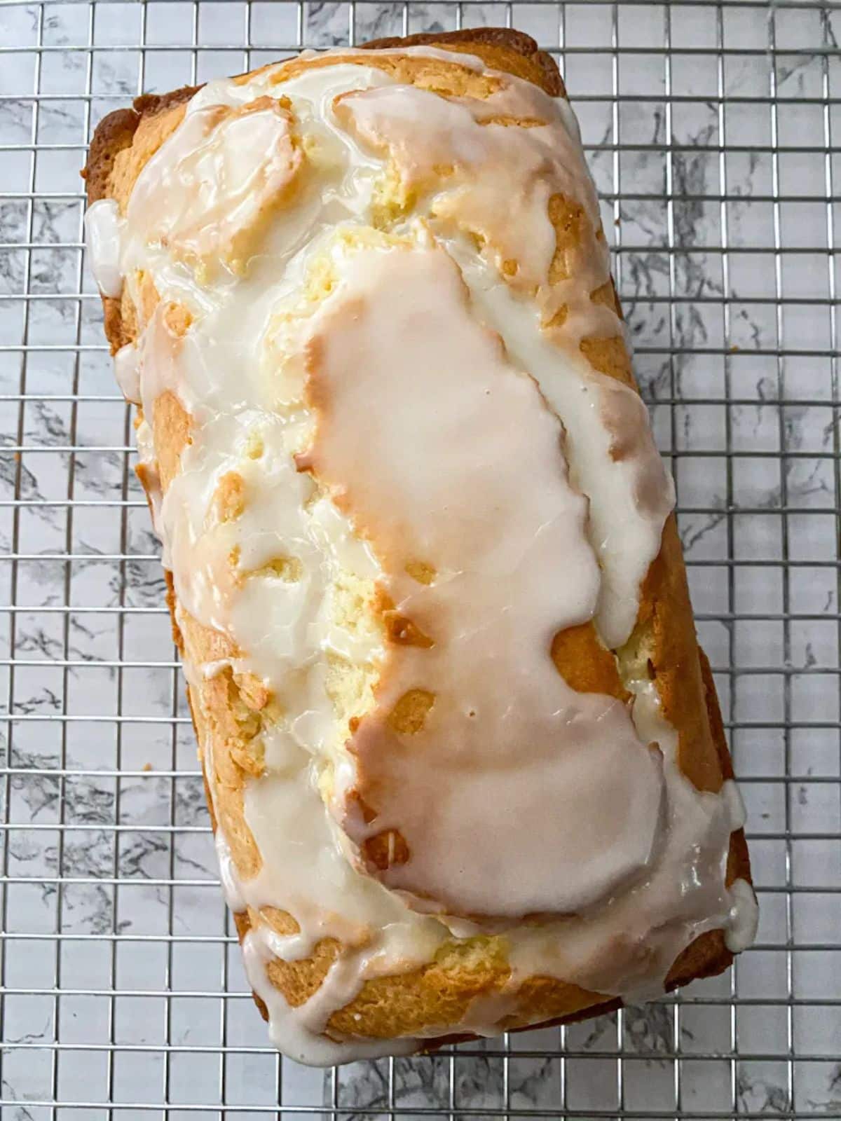 Healthy greek yogurt lemon loaf cake on a resting grid.