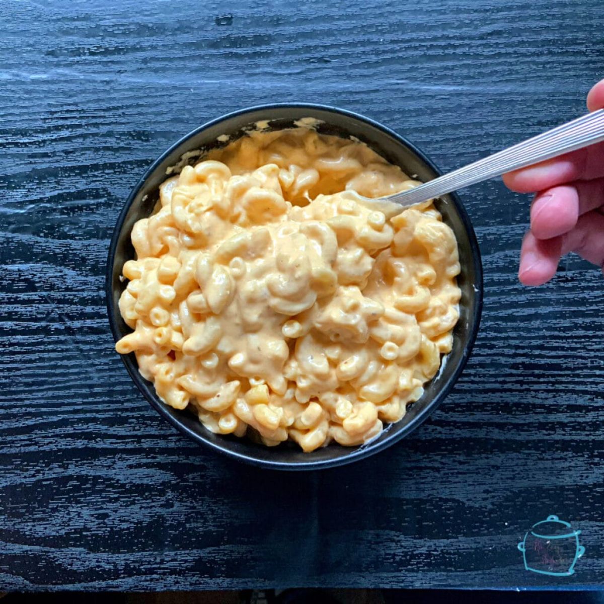 Mouth-watering slow cooker old bay mac and cheese in black bowl.