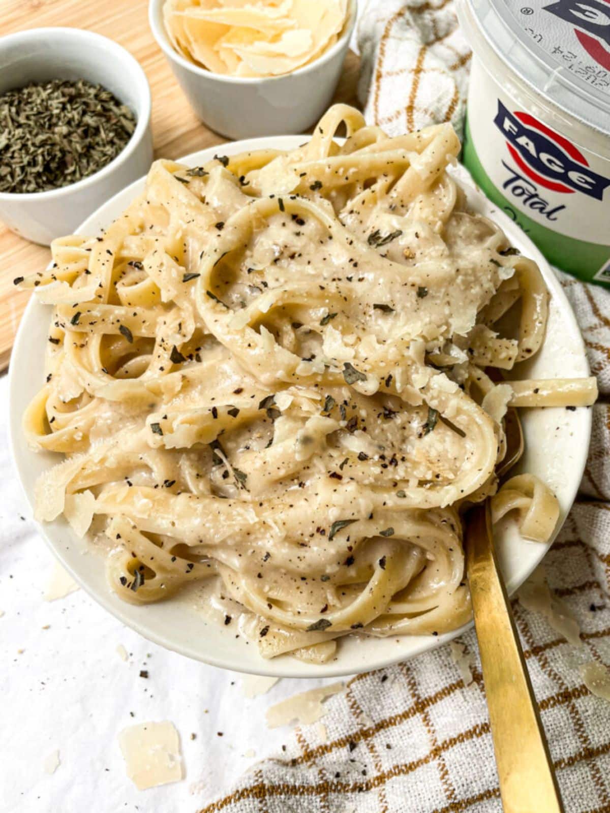 Healthy greek yogurt alfredo sauce pasta in a white bowl.