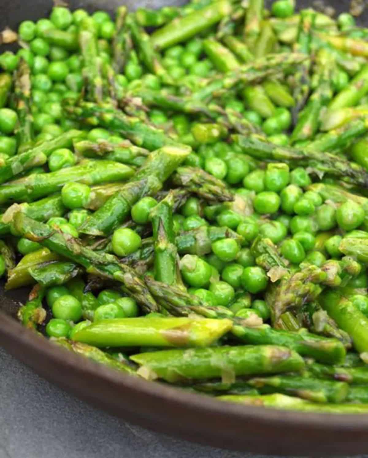 Healthy sauteed asparagus and peas in a bowl.