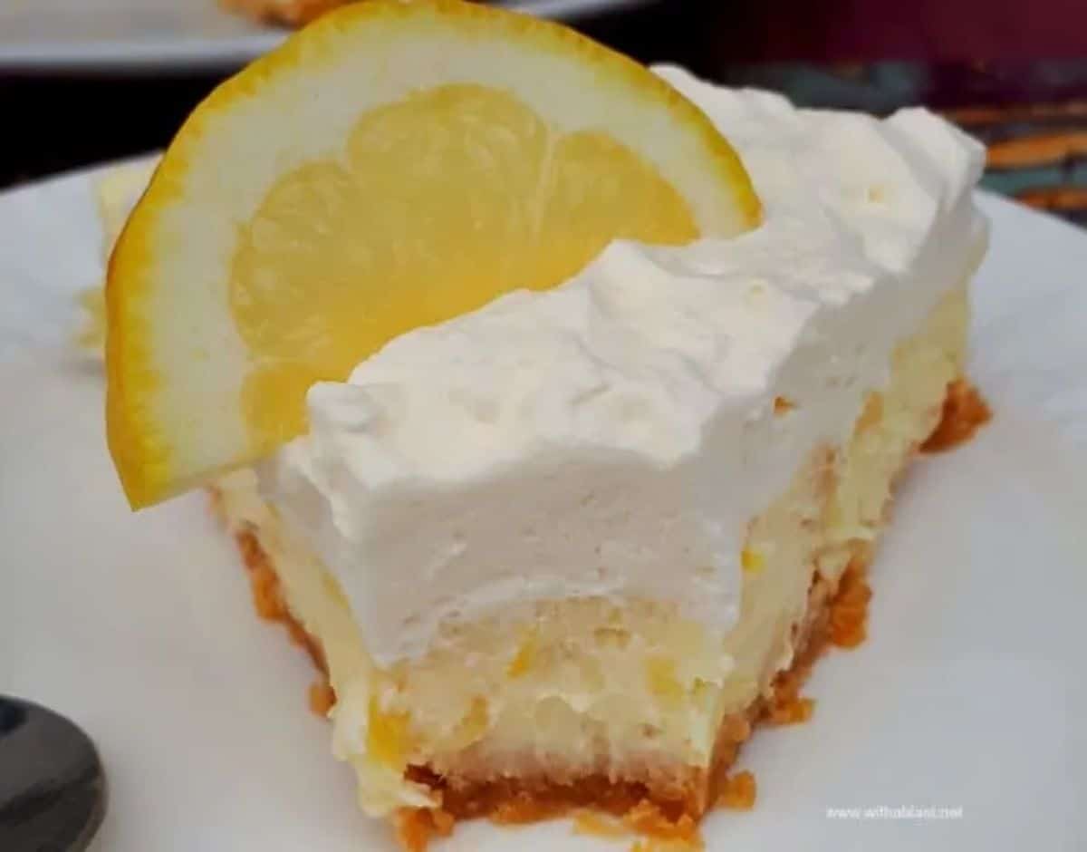 A piece of lemon pineapple cheesecake on a white plate.