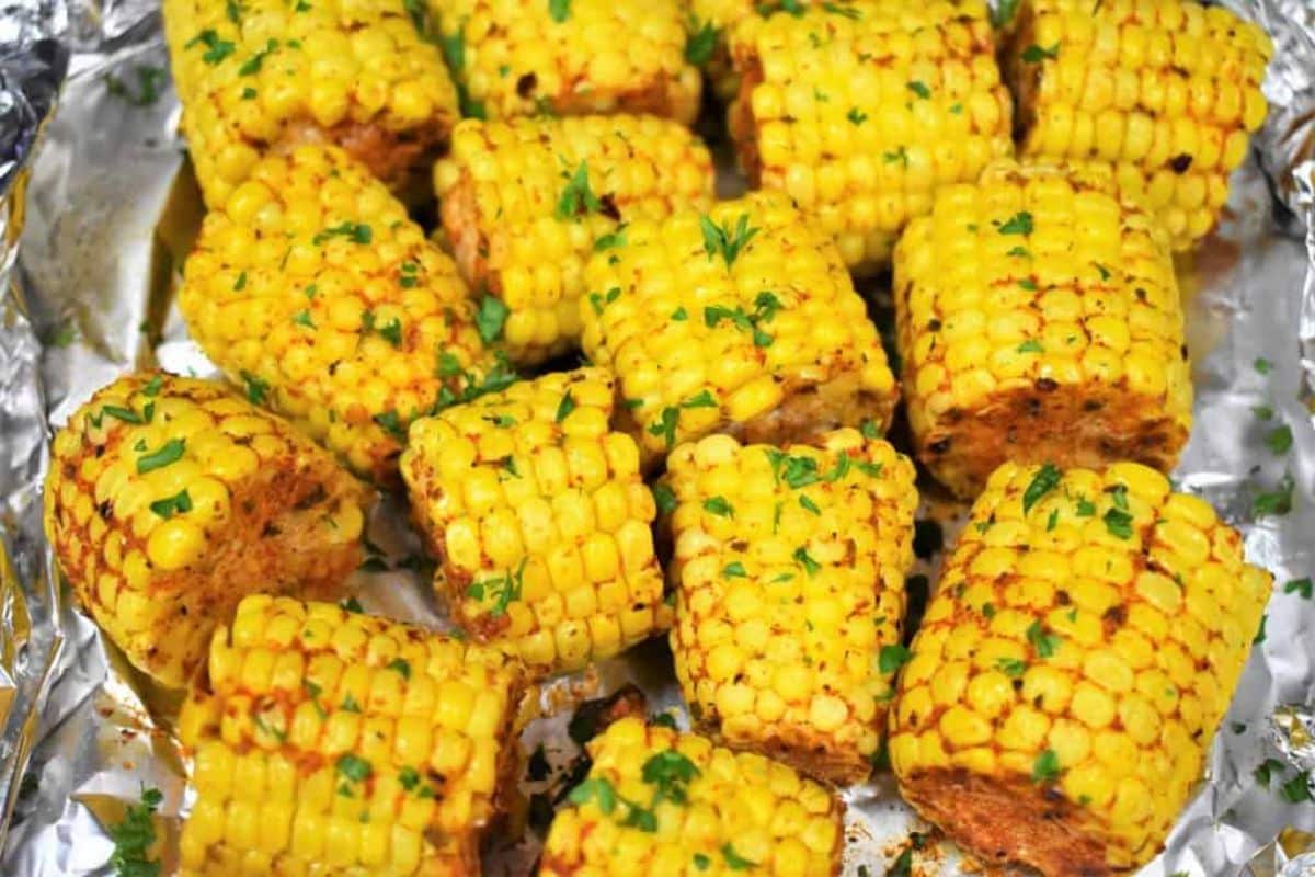 Crunchy seasoned corn on the cob on a baking foil.