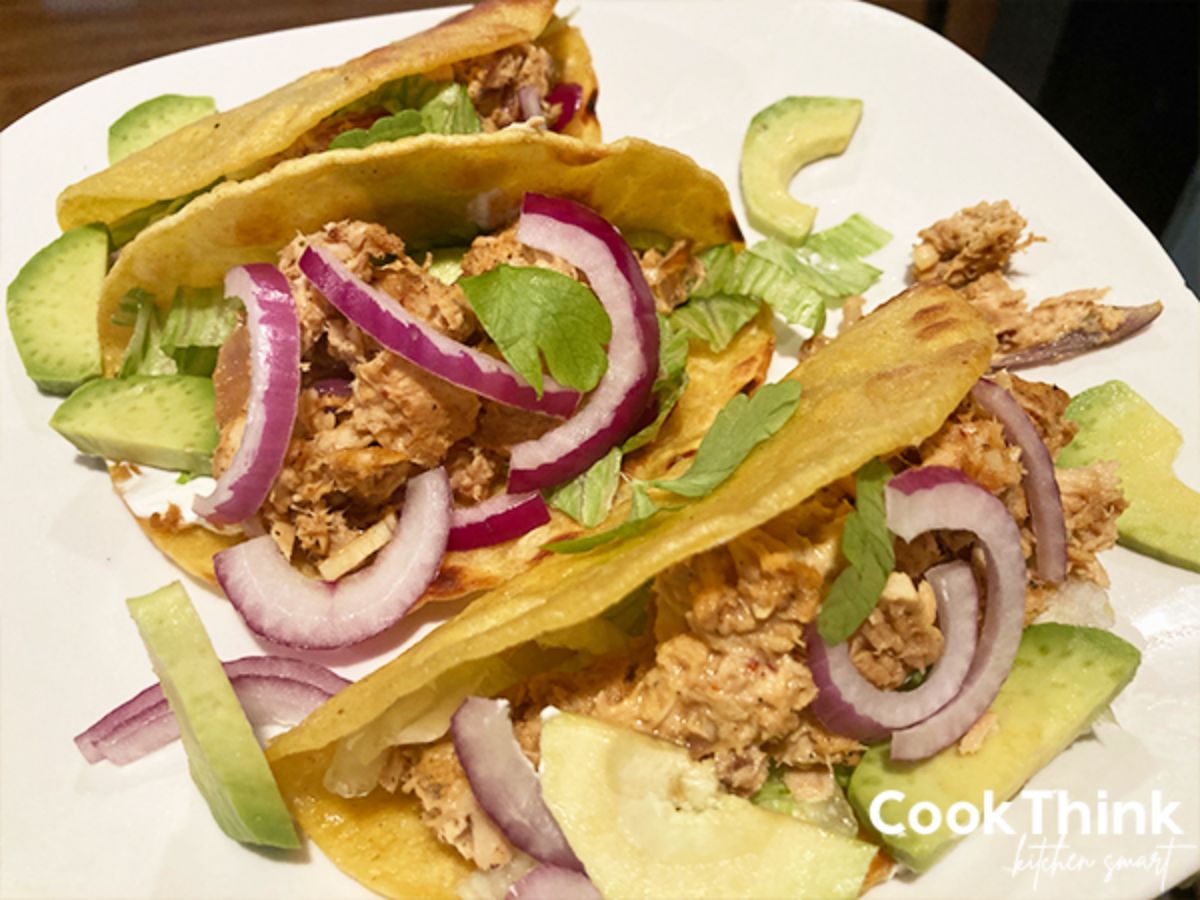 Tasty canned tuna tacos on a white plate.