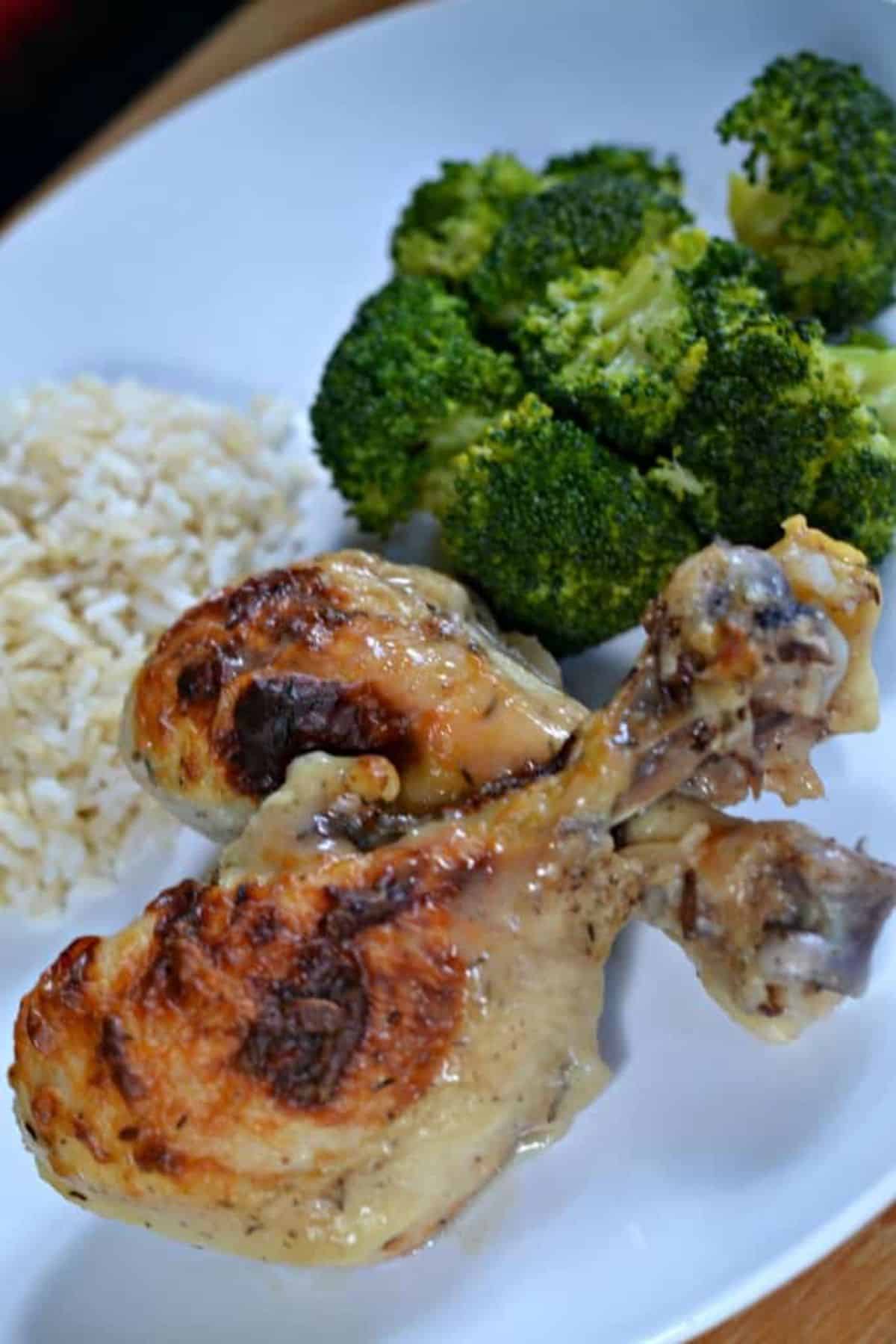 Juicy easy yogurt chicken with rice and broccoli on a white plate.