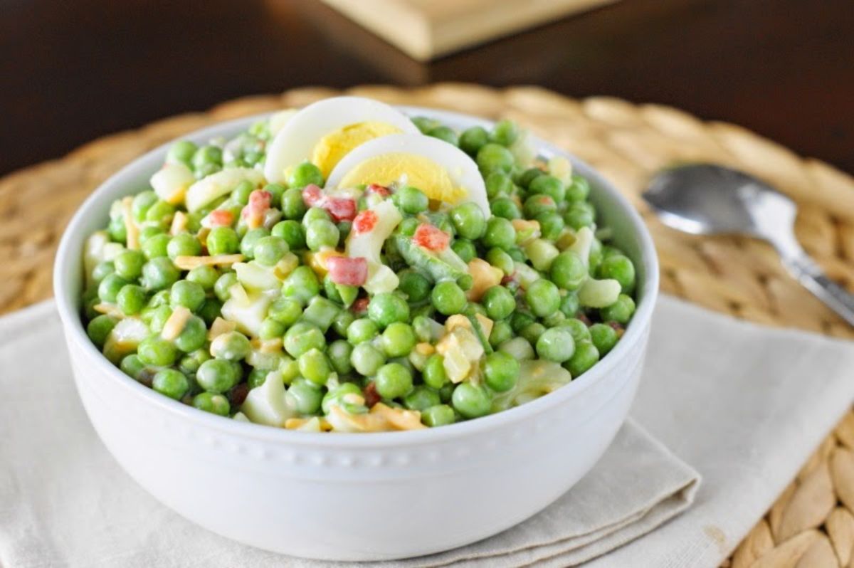 Fresh pea salad in a white bowl.