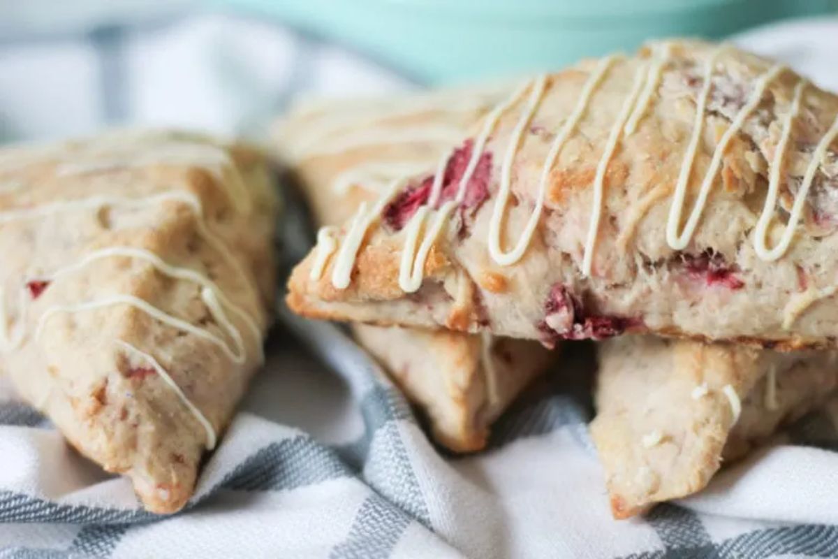 Tasteful strawberry scones on a table cloth.