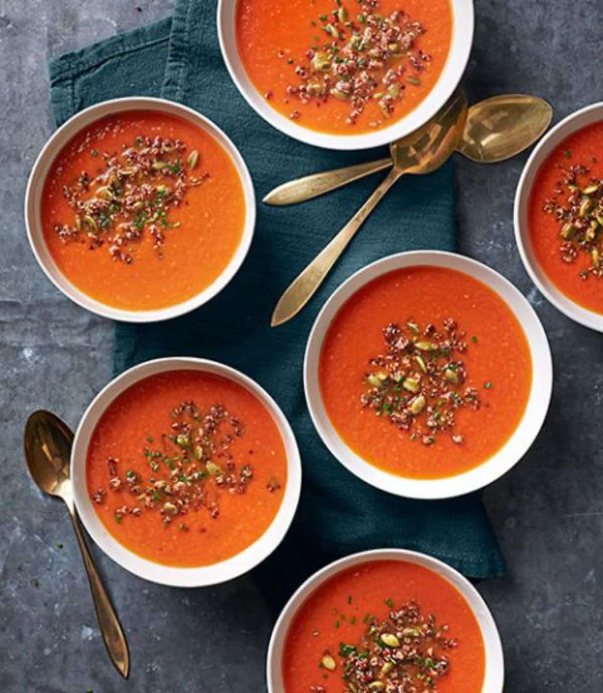 Creamy tomato quinoa soup in white bowls.