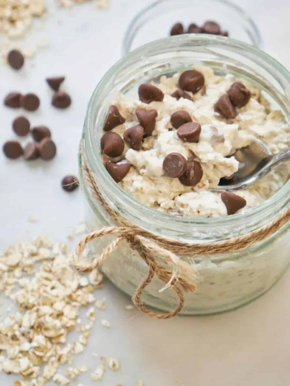 Healthy chocolate chip overnight oats in a glass jar with a spoon.