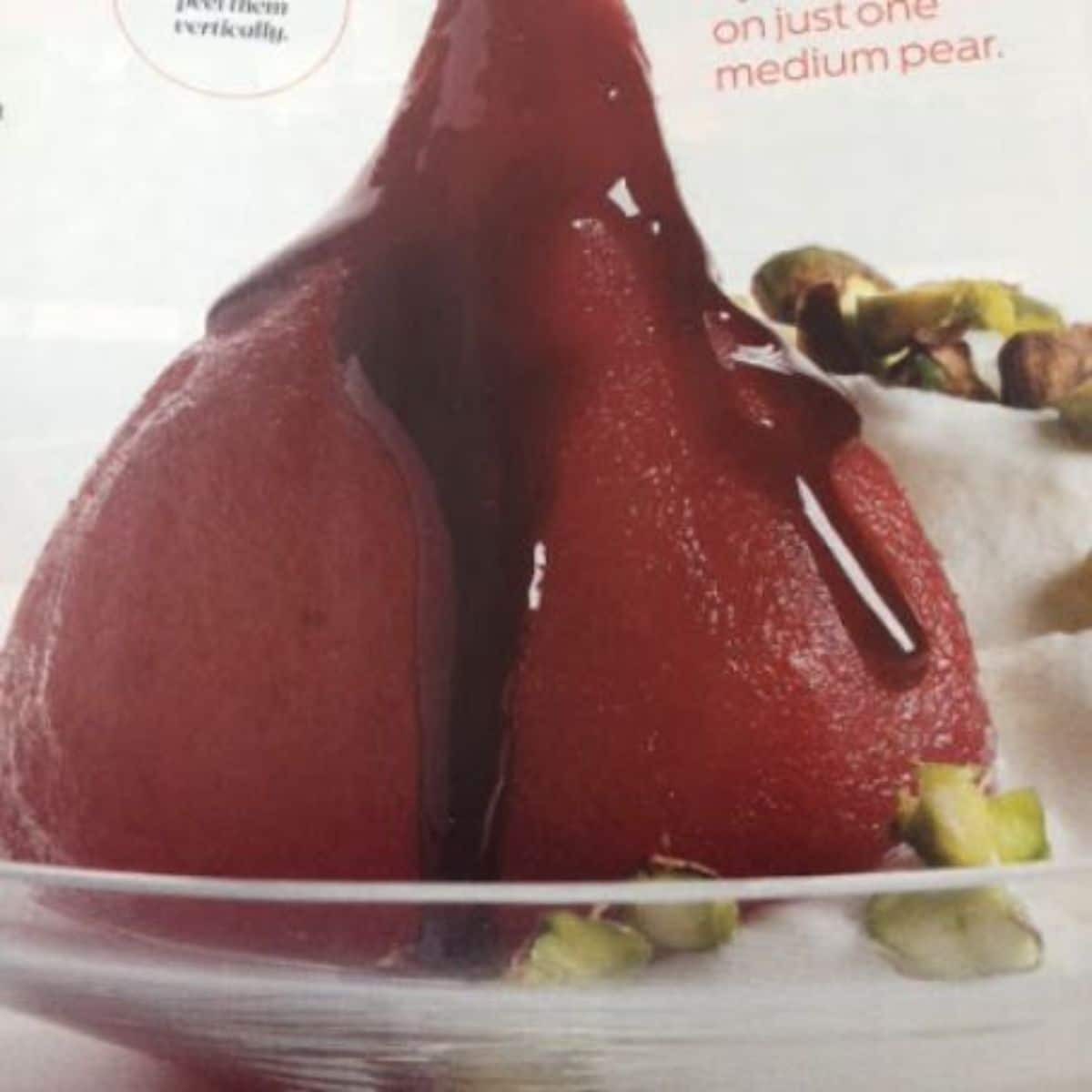 Flavorful wine-poached pears with greek yogurt cream on a glass plate.
