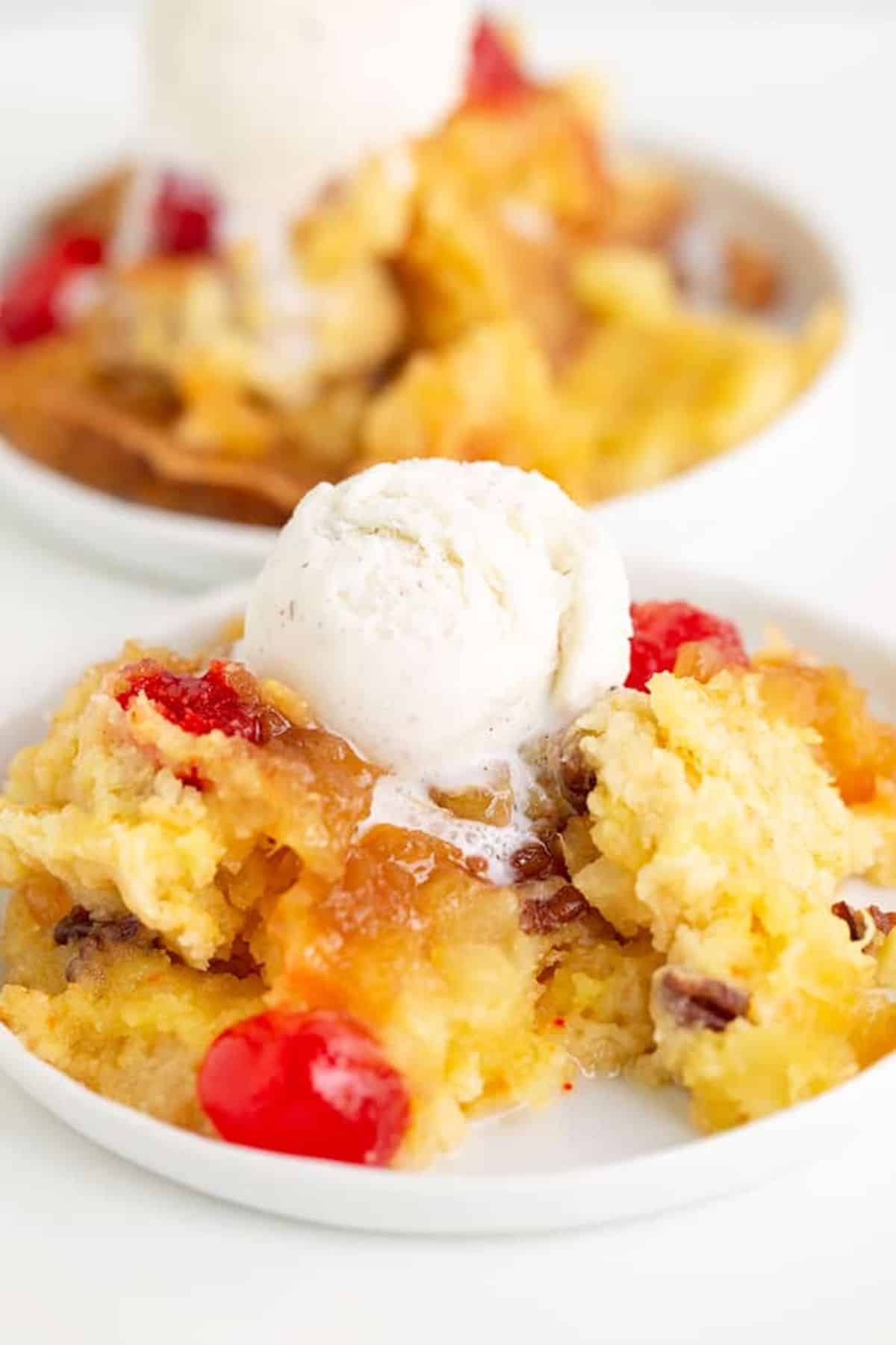 A piece of upside down pineapple dump cake on a white plate.