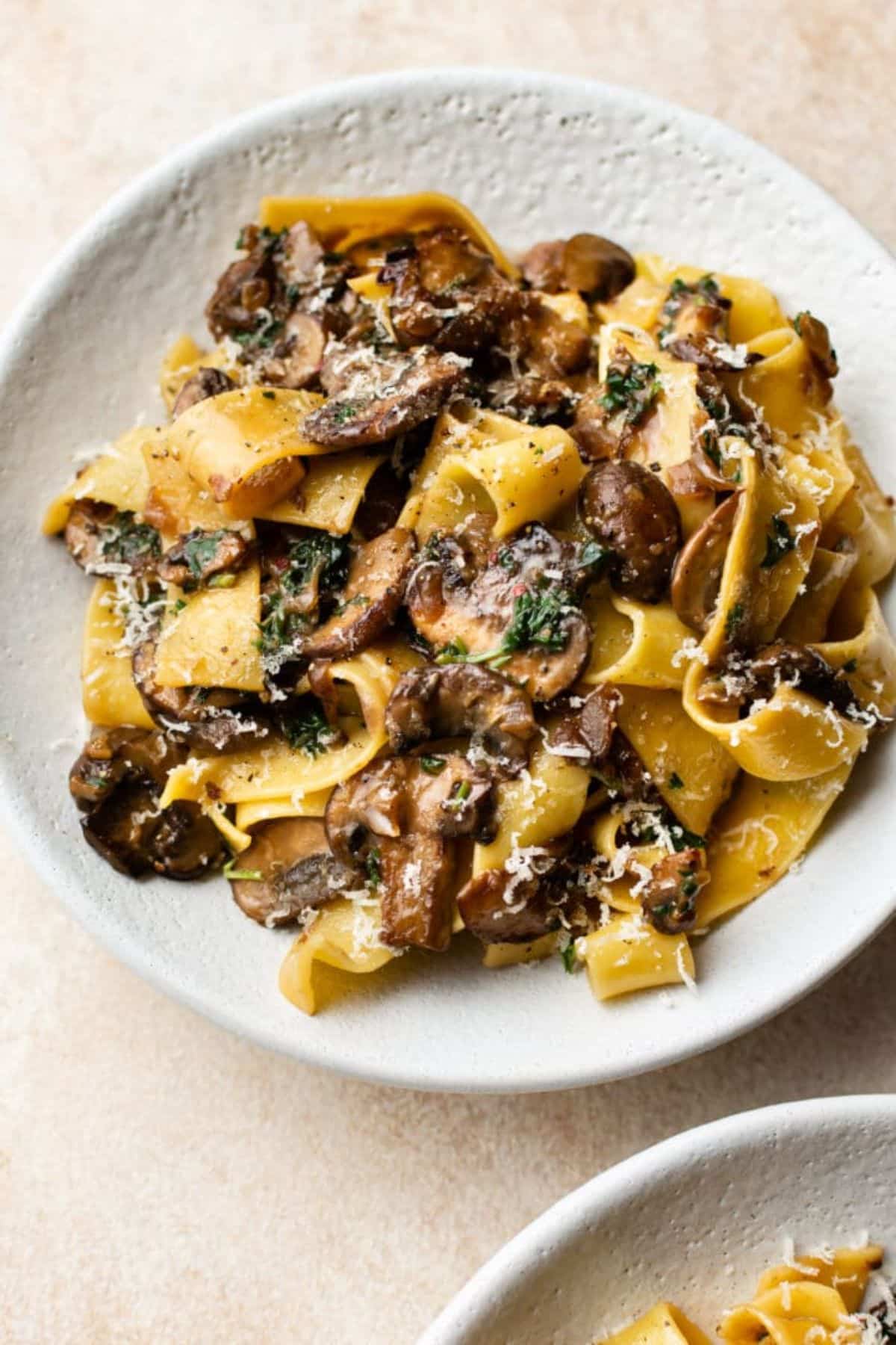 Healthy garlic mushroom pasta on a white plate.