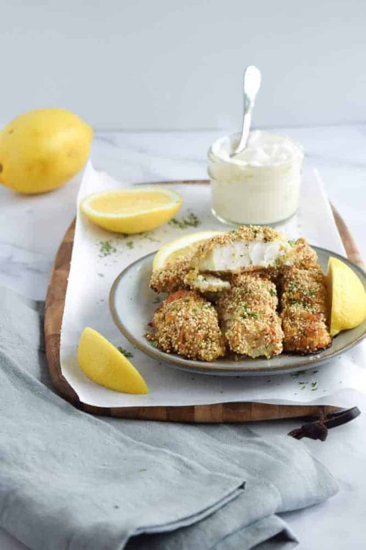 Crunchy quinoa-breaded fish sticks on a plate.