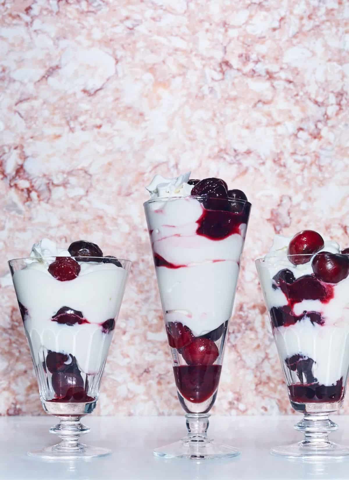 Fresh maraschino cherry parfaits in tall glasses.