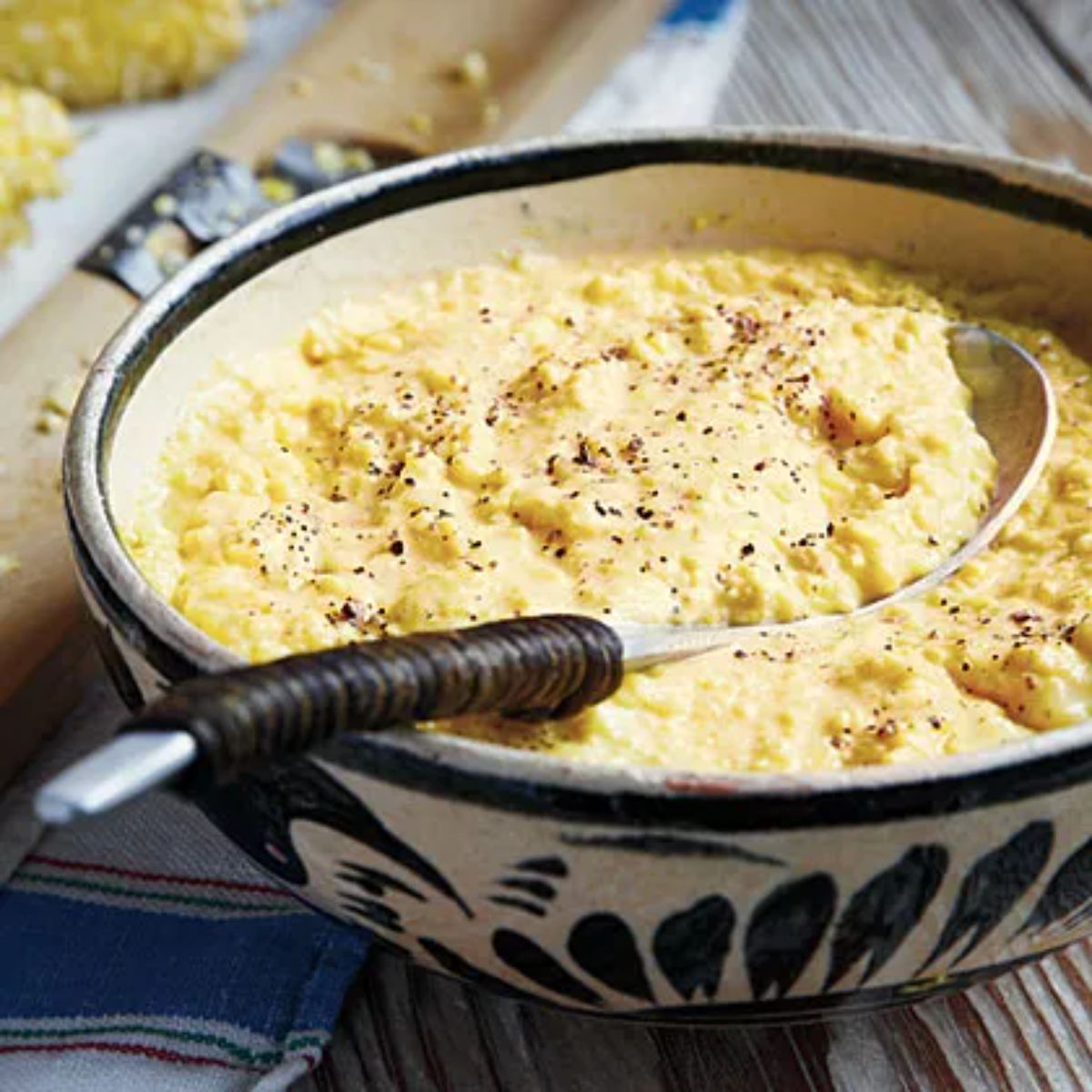 Delicious creamed queen corn in a bowl with a spoon.