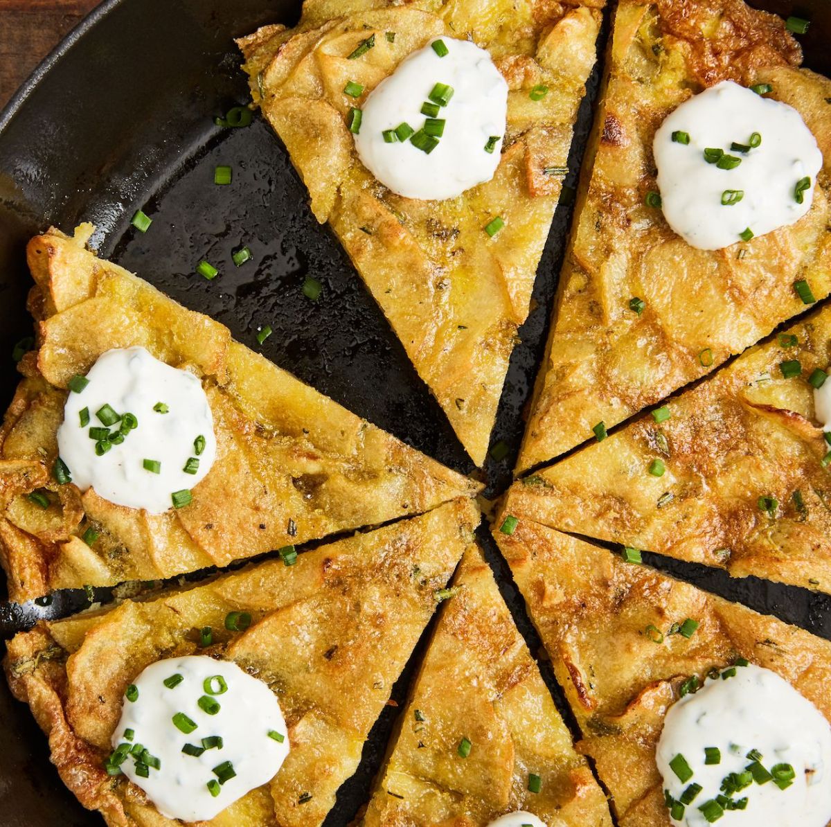 Scrumptious sour cream spanish tortilla in a black skillet.